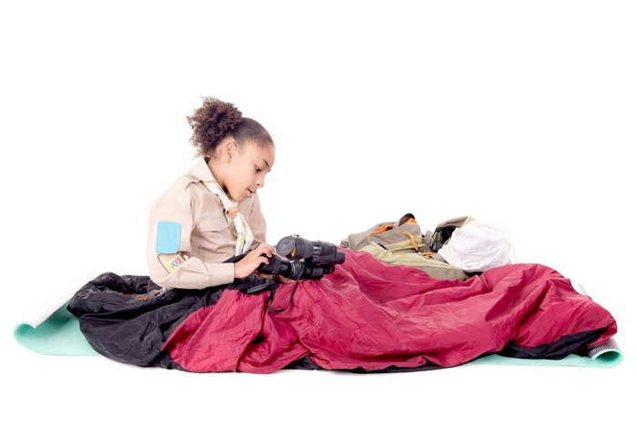 Girl scout with camping gear and camera