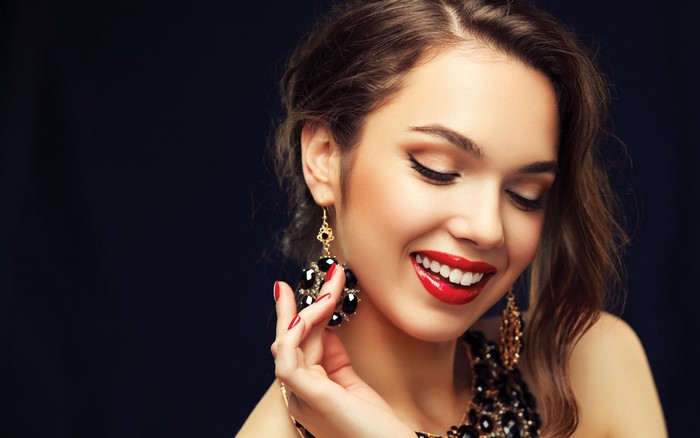 Woman with red lips and large earrings smiling