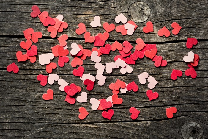 Red and pink heart confetti on wood