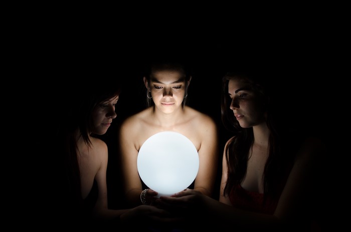 Three women around a glowing orb