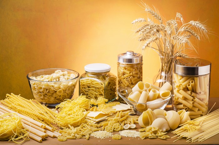 Various pasta types and wheat stalks