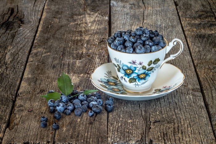 Blueberries in a teacup on wooden planks