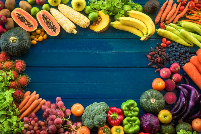 Assortment of Fresh Fruits and Vegetables on Blue Wooden Planks