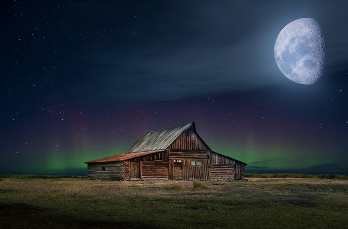 Wooden barn under the moon and aurora