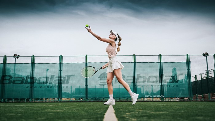 Katrin Sarkozy serving tennis ball on court