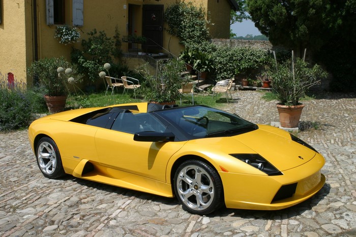 Yellow Lamborghini Roadster parked on cobblestone