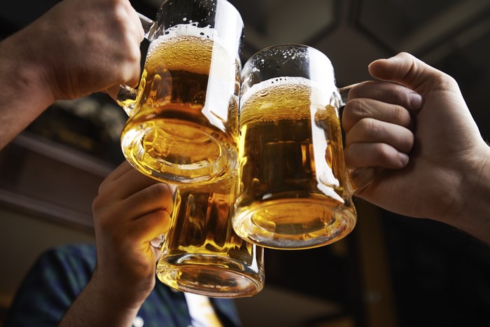 Three hands clinking beer mugs