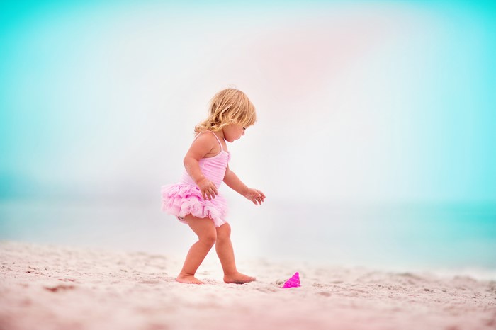 Little girl in pink swimsuit on a beach