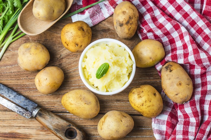 Potatoes and mashed potatoes on a wooden table