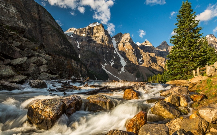 River flowing through rocky terrain with mountains and trees