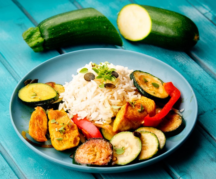 Rice with grilled chicken and zucchini on a plate