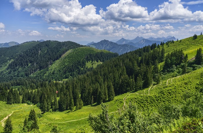 Green mountains and forests in Bavaria, Germany under a cloudy sky