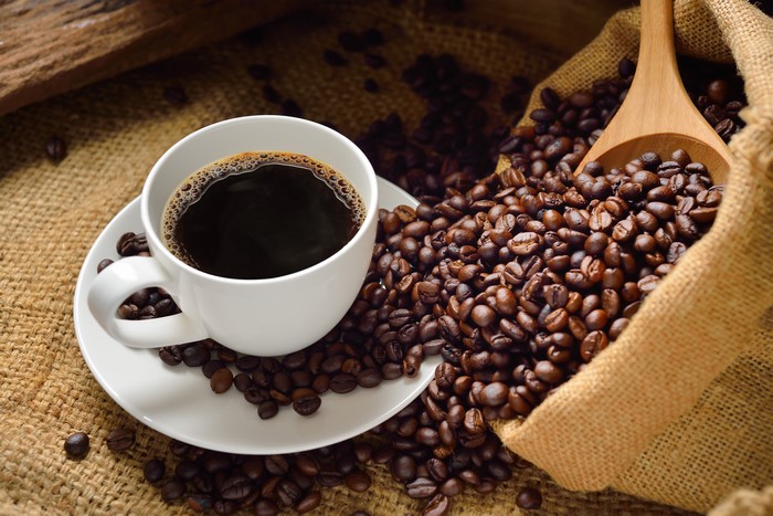 Coffee cup and beans in burlap sack