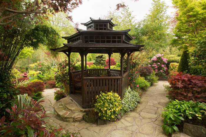Gazebo in a lush garden with stone pathways