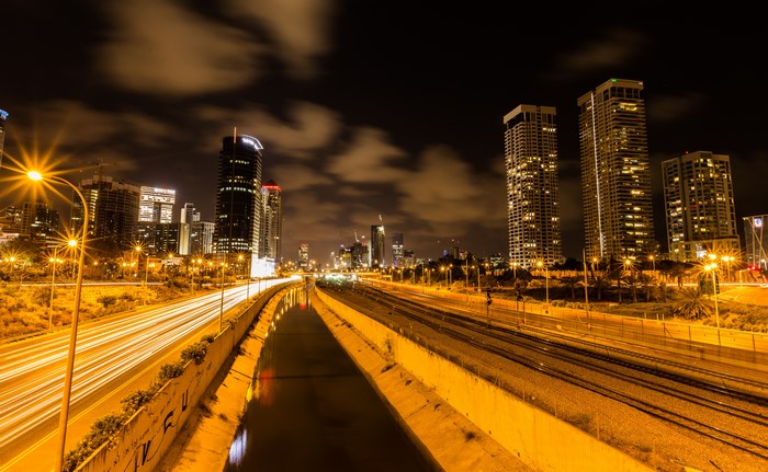 Tel Aviv cityscape at night with traffic and canal