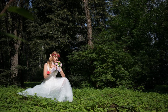 Elf bride with bouquet in forest
