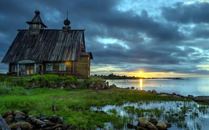 Wooden church on the coast of Karelia at sunset