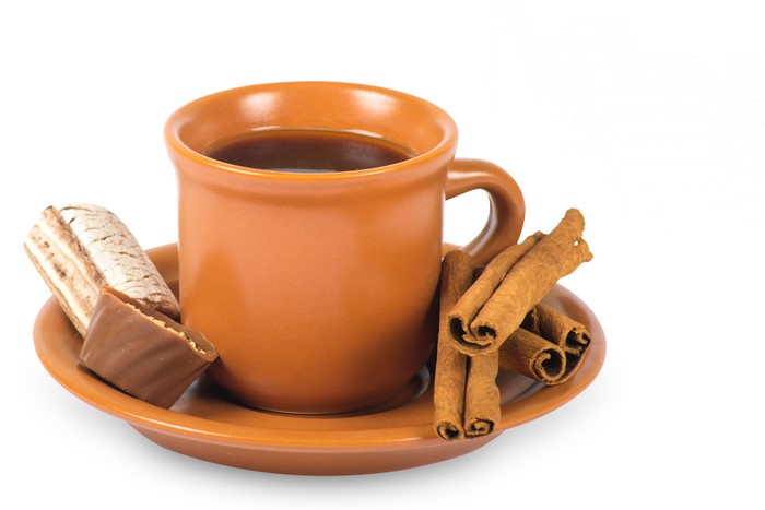 Coffee mug with cinnamon sticks and candy on a saucer