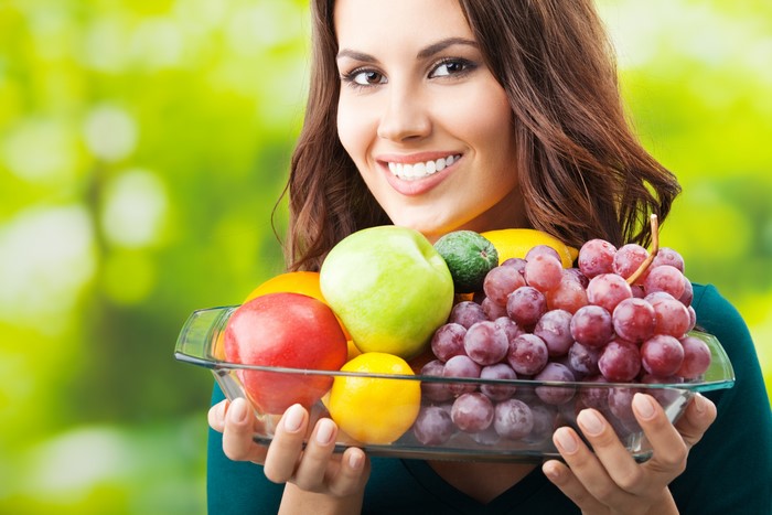 Woman holding a bowl of fruit