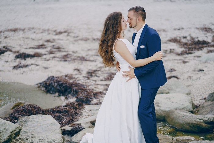Bride and Groom kissing on a rocky beach