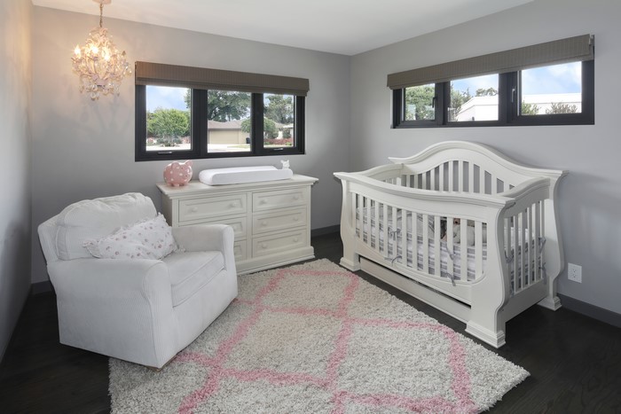 Nursery with crib, armchair, and dresser