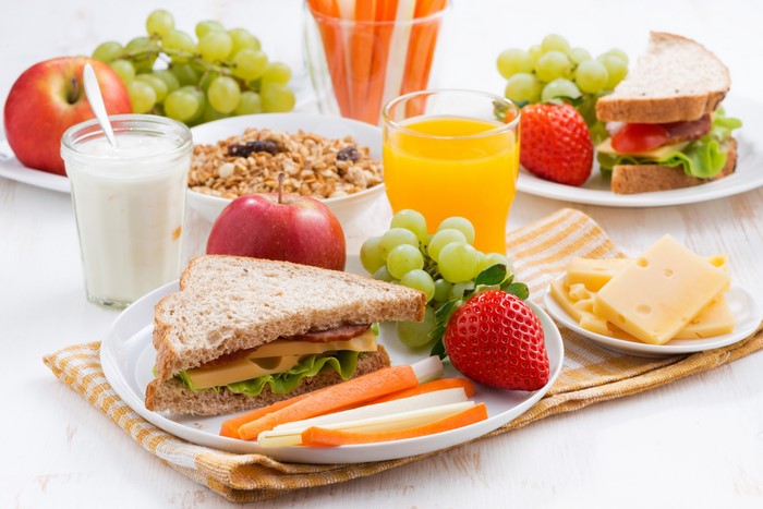 Breakfast with sandwiches, fruit, juice, and cheese