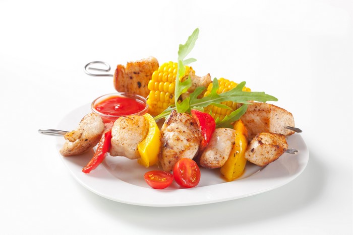 Shashlik with vegetables and ketchup on a plate