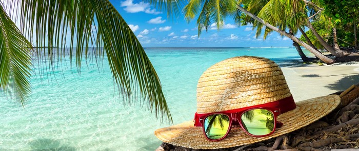Straw hat and sunglasses on a tropical beach