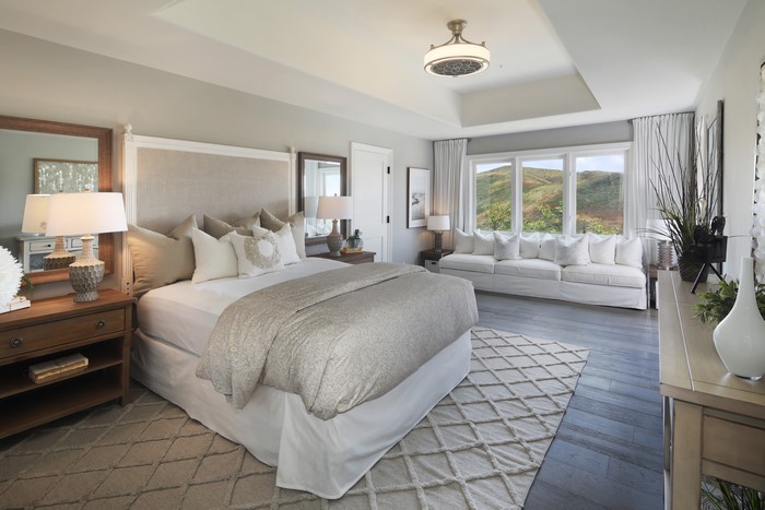 Bedroom with large bed, sofa, and scenic view