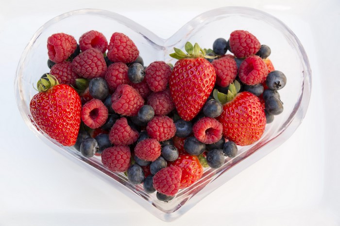 Heart-shaped bowl of strawberries, raspberries, and blueberries