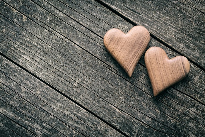 Two wooden hearts on a rustic wooden surface