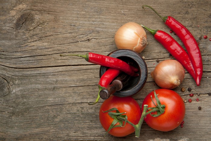 Tomatoes, Onion, Chili Pepper, and Mortar on Wood