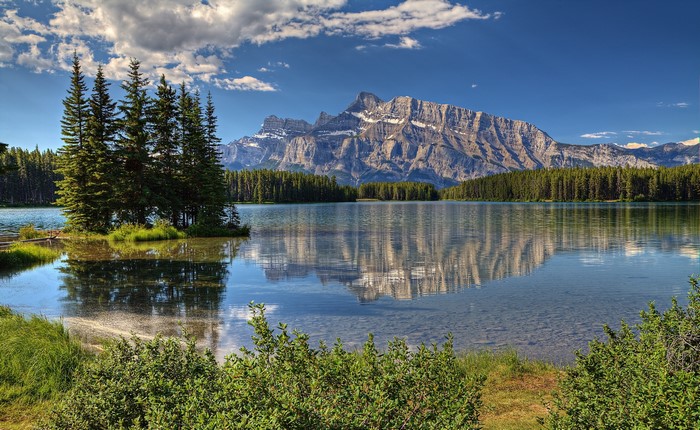 Canadian Rocky Mountains reflected in a lake with trees