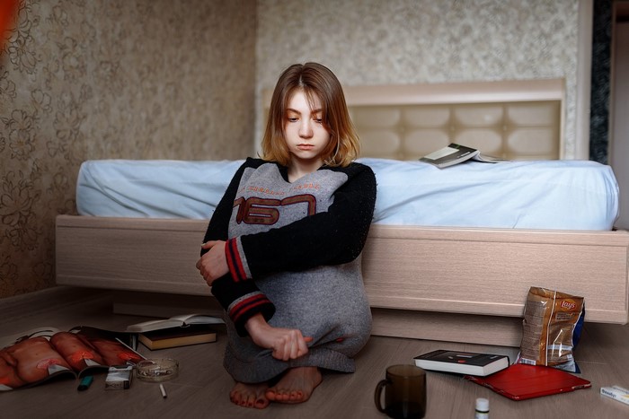 Girl sitting on the floor in a bedroom