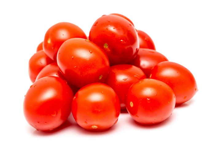 Many red tomatoes on a white background