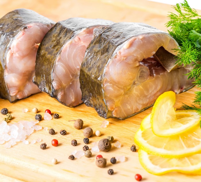 Raw fish steaks with lemon slices and spices