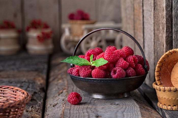 Bowl of fresh raspberries with mint leaf