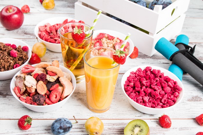 Healthy breakfast with juices, dried fruits, and dumbbells