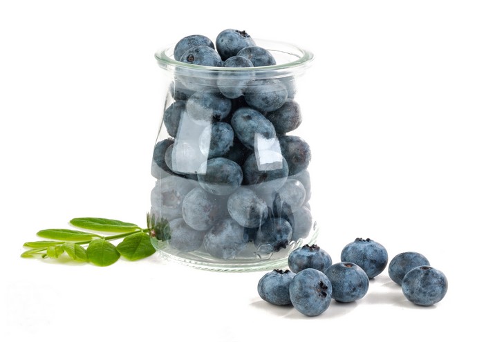 Blueberries in a glass jar with leaves