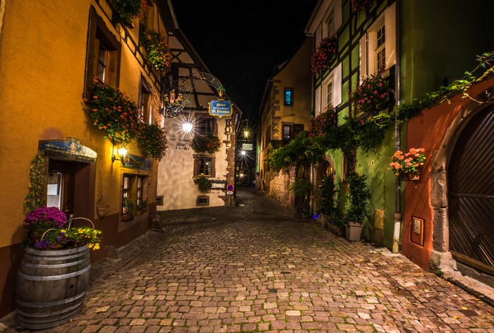 Cobblestone street at night in Riquewihr, France