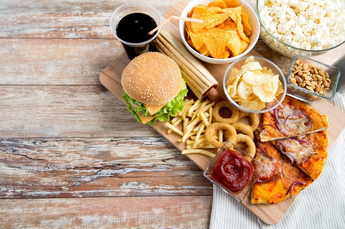 Fast food spread with hamburger, pizza, fries, and chips
