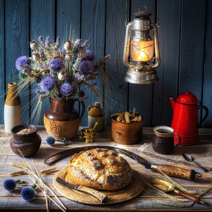 Still life with bread, flowers, and a kerosene lamp