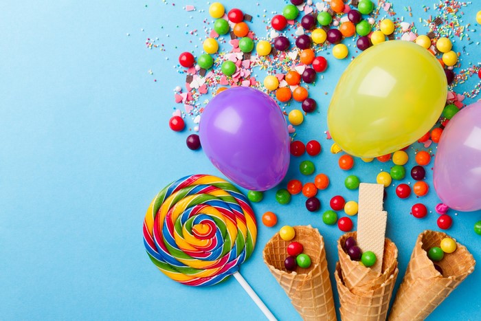 Colorful candies, balloons, and ice cream cones on blue background