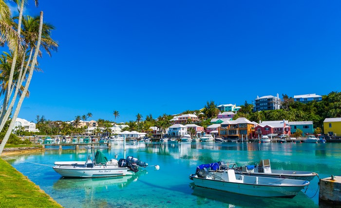 Boats in a bay with colorful houses in Harrington Sound, Bermuda