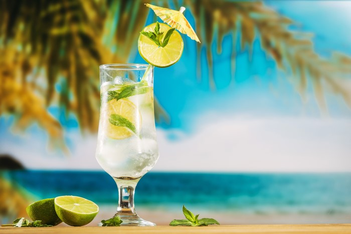 Mojito cocktail with lime and mint on a beach