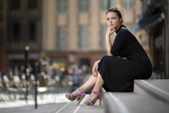 Woman in black dress sitting on stairs