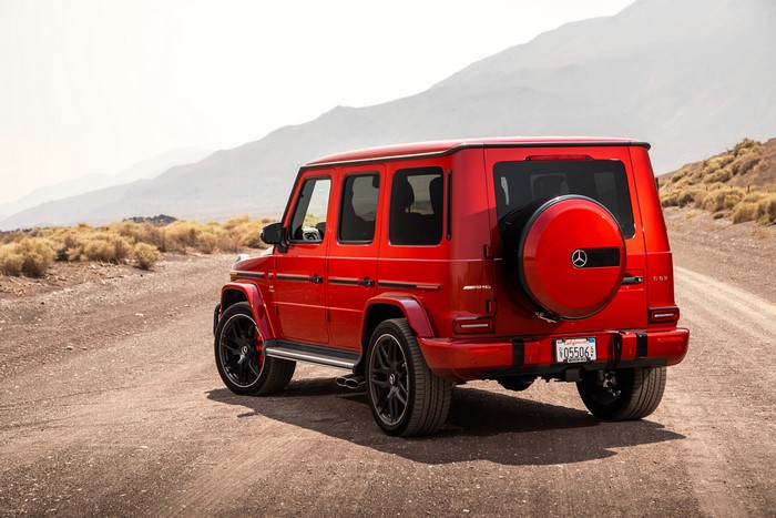 Red Mercedes-Benz AMG G63 G-Class SUV on a dirt road
