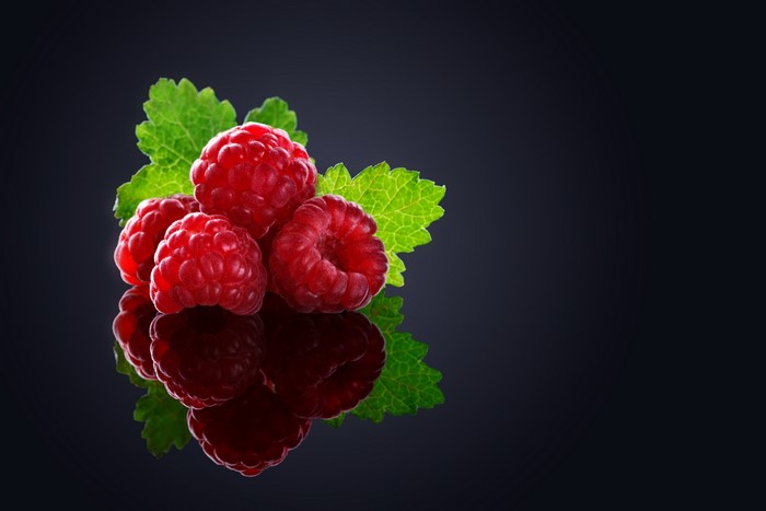 Raspberries with leaves and reflection