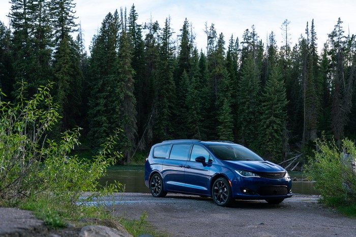 Blue Chrysler Pacifica parked by a forest lake