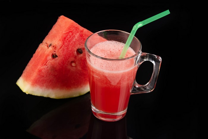 Watermelon juice in a mug with a slice of watermelon